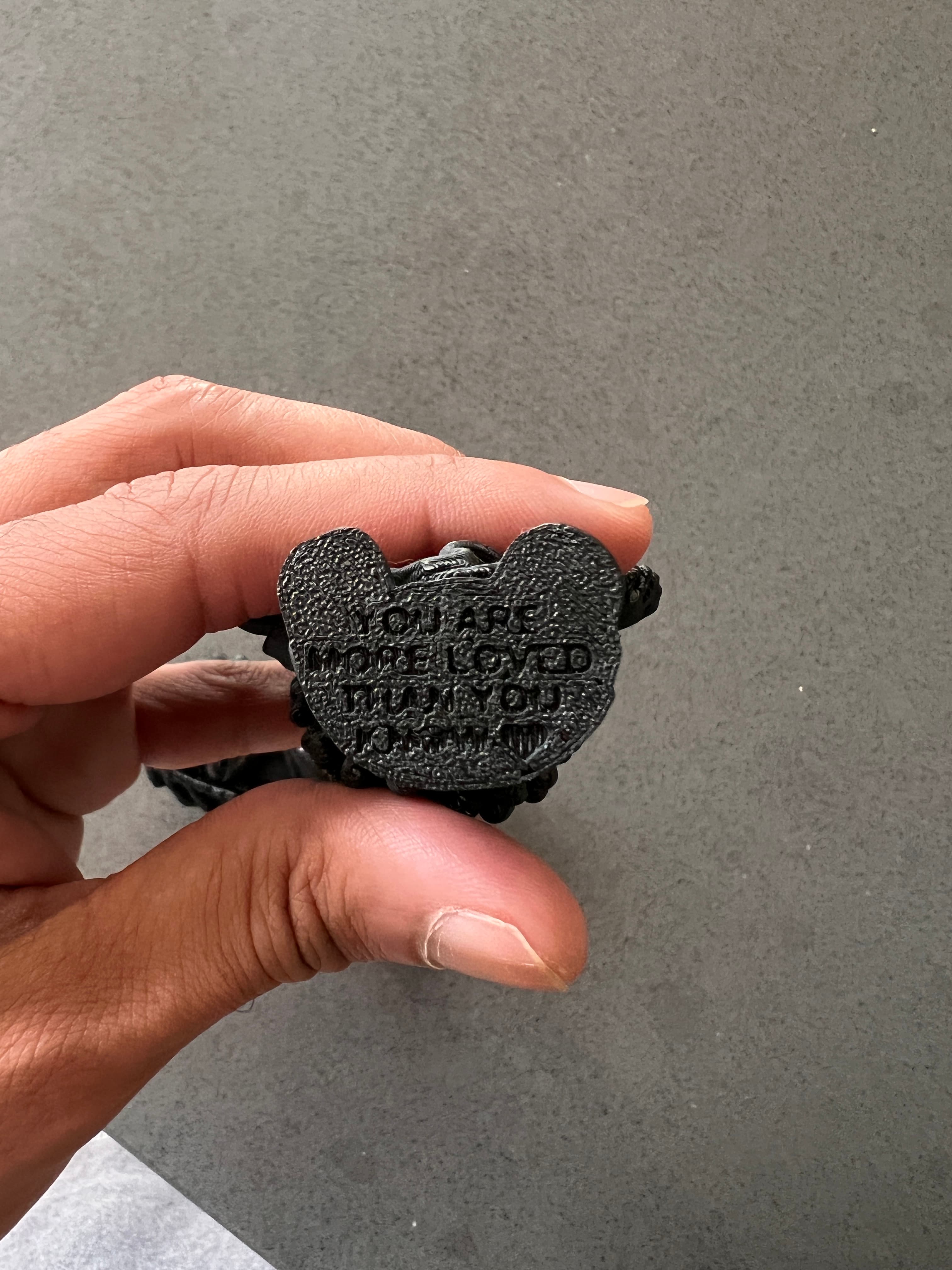 Underside of Tiny Black Jesus showing the engraved message